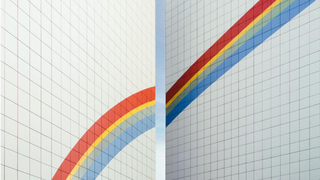 Zwei gekachelte Mauern mit einem durchgehenden, aber zwischen den Mauern durchtrennten Regenbogen.